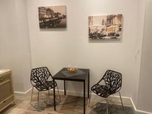 mesa y 2 sillas en una habitación con mesa en La cour de la Trésorerie en Metz