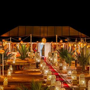 a long table with lights in front of a tent at Fabulous luxury camp in Merzouga