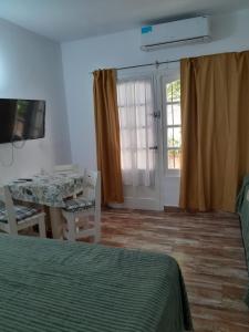 1 dormitorio con cama, mesa y ventana en Mono Yoly en Villa Gesell