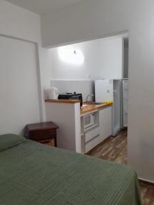 um pequeno quarto com uma cozinha e uma cama em Mono Yoly em Villa Gesell