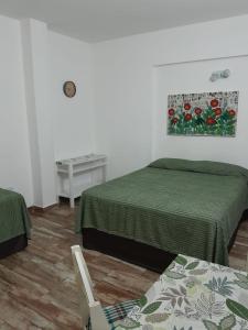 Habitación con 2 camas y mesa con silla. en Mono Yoly en Villa Gesell