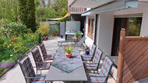 a patio with a table and chairs and a grill at Gästehaus Aachblick, Exklusive Appartements und Ferienwohnungen in Uhldingen-Mühlhofen