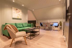 sala de estar con sofá verde y mesa en Urban and stylish apartment in city centre en Tromsø