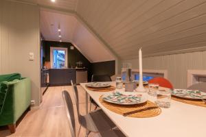 uma sala de jantar com uma mesa longa e cadeiras em Urban and stylish apartment in city centre em Tromsø