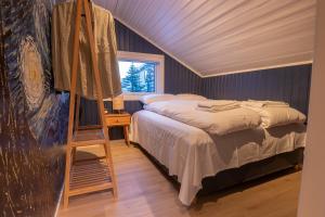 a bedroom with a bed and a painting and a ladder at Urban and stylish apartment in city centre in Tromsø