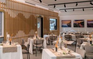 une salle à manger avec des tables et des chaises blanches dans l'établissement Seaside Hotel, à Capo dʼOrlando