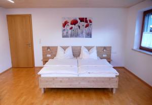 a bedroom with a large white bed with white pillows at Alpenferienwohnung Deluxe in Bürs