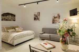 Un dormitorio con una cama y una mesa con un jarrón de flores en Casa Falcucci, en Gubbio
