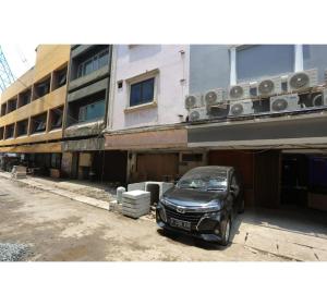 a black car parked in front of a building at Capital O 93261 Fresh Hotel Near Stasiun Jakarta Kota in Jakarta