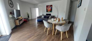 a living room with a table and chairs and a couch at Apartament Riva in Pobierowo