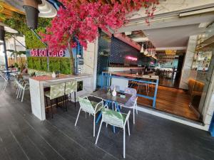 a restaurant with tables and chairs and pink flowers at Gazi Apartment with Breakfast in Athens