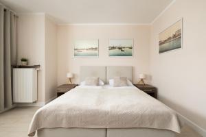 sypialnia z dużym łóżkiem i dwoma szafkami nocnymi w obiekcie Apartamenty Aquamarina by Noclegi Renters w Świnoujściu
