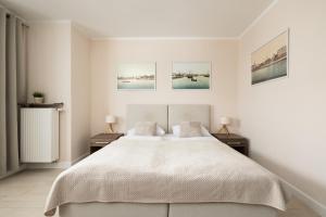 シフィノウイシチェにあるApartamenty Aquamarina by Rentersのベッドルーム1室(大型ベッド1台、ナイトスタンド2台付)
