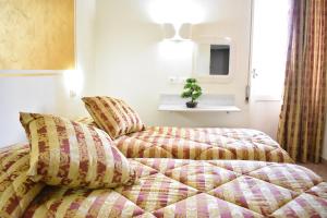 een slaapkamer met een bed met een quilt bij Hotel Il Parco in Grosseto