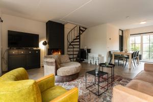 uma sala de estar com um sofá, cadeiras e uma mesa em Hello Zeeland - Spaanse Galeien 35 em Retranchement