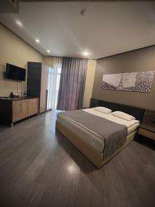 um quarto com uma cama grande e uma televisão em Bien hotel em Yerevan