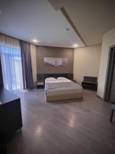 a large bedroom with a bed and a large window at Bien hotel in Yerevan