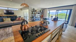 uma cozinha com uma placa de fogão e uma sala de estar. em House of Anjel em Suider-Paarl