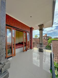 Cette maison dispose d'un balcon avec un lit. dans l'établissement Ojek's Homestay, à Ubud