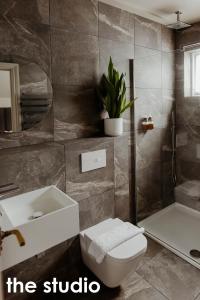 een badkamer met een toilet, een wastafel en een bad bij HIDEOUT Hotel in Hull