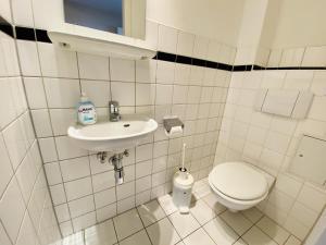a white bathroom with a toilet and a sink at Landhaus Immenbarg, Alter Strom in Warnemünde