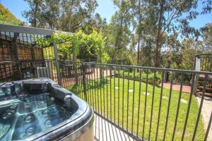 a hot tub on a balcony with a fence at Apex Villa in Bright