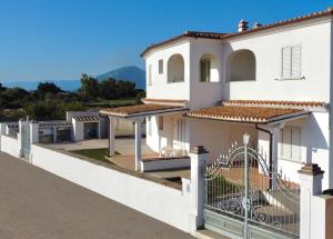 a large white house with a fence at ISA-Residence in Orosei just 3 km from the beach, apartments with air conditioning and private outdoor area in Orosei