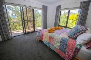 a bedroom with a bed and large windows at Apex Villa in Bright