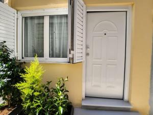 a white door on a house with a window at Gazi Apartment with Breakfast in Athens