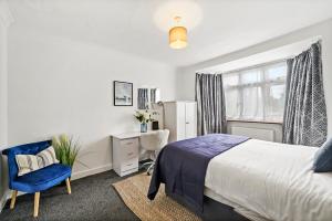 1 dormitorio con cama, silla y escritorio en Greenford Hububb Stay, en Northolt