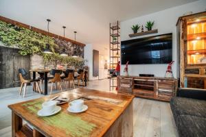 Rodzinny stylowy dom z jacuzzi في ميلنو: غرفة معيشة مع طاولة وتلفزيون