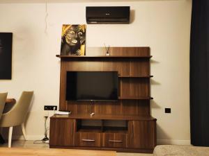 a living room with a television on a wooden entertainment center at Hermes rezidans in Antalya