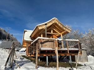 a wooden cabin in the snow with snow at Cabane Insolite de la Semine in La Pesse