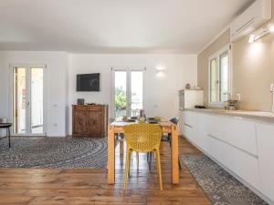 uma cozinha com uma mesa de madeira e cadeiras amarelas em Villa Mika em Capitana