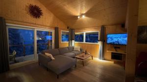a living room with a couch and a flat screen tv at Chalet Bastion in Turracher Hohe