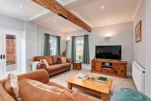 a living room with a couch and a tv at Finest Retreats - South Barn in Winestead