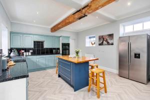 a kitchen with blue cabinets and a blue island at Finest Retreats - South Barn in Winestead