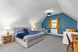 a bedroom with a bed and a blue wall at Finest Retreats - South Barn in Winestead