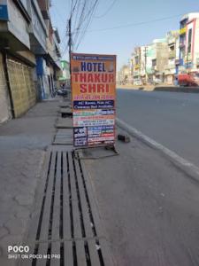 un panneau assis sur le côté d'une rue dans l'établissement HOTEL THAKUR SHRI , BHOPAL, à Bhopal