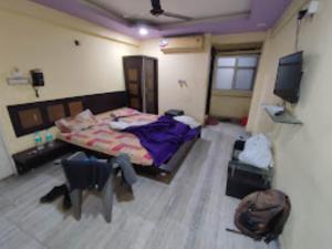 - une chambre avec un lit et une télévision dans l'établissement HOTEL THAKUR SHRI , BHOPAL, à Bhopal