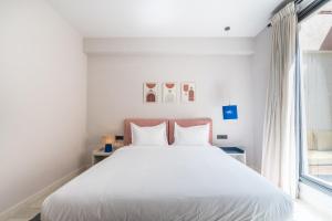 a bedroom with a white bed and a window at JEMAA EL FNA Suites & Spa in Marrakech