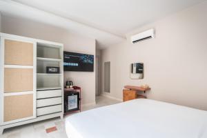 a bedroom with a white bed and a tv at JEMAA EL FNA Suites & Spa in Marrakesh