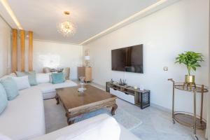- un salon avec un canapé blanc et une télévision dans l'établissement ANFA LIVING - LES TERRASSES D'ANFA # Front Sea VIEW 180 - 2 or 3 bedrooms, à Casablanca