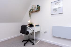 a white desk with a chair and a lamp at Your Northampton Apartments Haven in Northampton