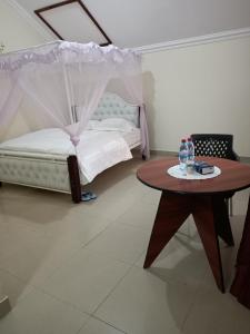 a bedroom with a bed and a table with a canopy at Amigo apartments in Kisumu