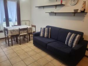 ein Wohnzimmer mit einem blauen Sofa und einem Tisch in der Unterkunft MIRABELLO in Verbania