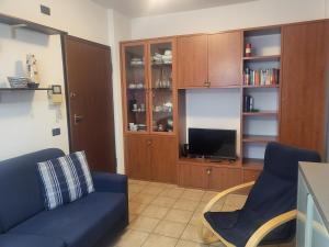ein Wohnzimmer mit einem blauen Sofa und einem TV in der Unterkunft MIRABELLO in Verbania