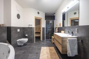 a bathroom with a sink and a toilet and a shower at Park-Apartment Scharmützelsee Wohnung 12 in Wendisch Rietz +8 photos