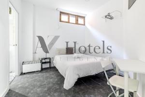 Dormitorio blanco con cama y cartel en la pared en AYZ Ulises - Auto check-in property, en Madrid