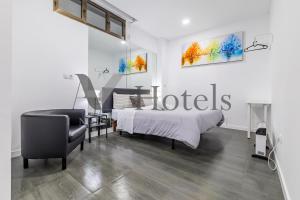 un dormitorio con una cama y una silla en AYZ Ulises - Auto check-in property, en Madrid